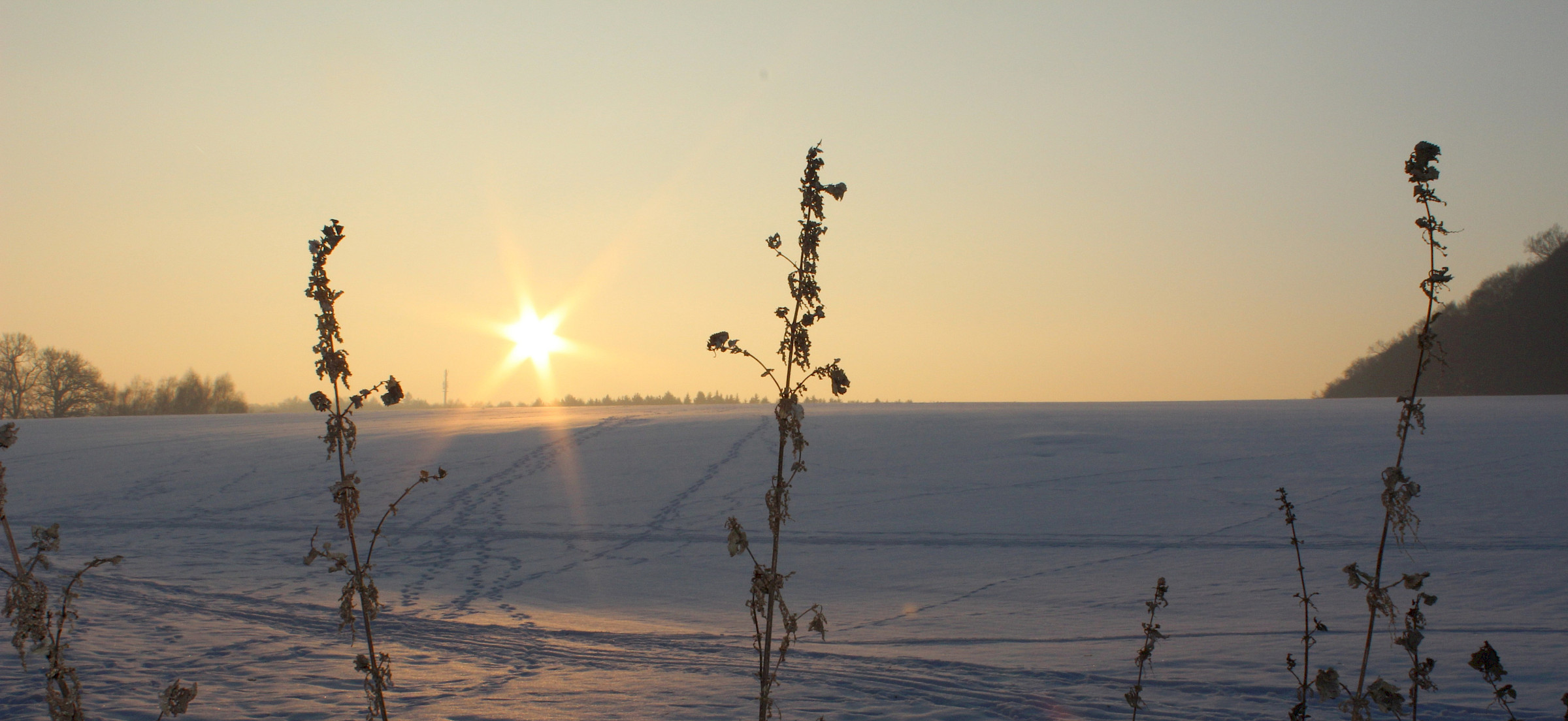 Schneelandschaft mit untergehender Sonne